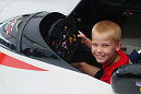 A young fan sits in a Panoz LMP01 Prototype