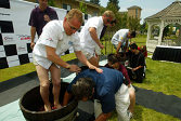 Johnny Herbert leans on his "swabbie" teammate on his way to winning the grape stomp competition in Napa, Calif