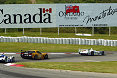 Three cars drive under the signs of Canada and Ontario as they practice